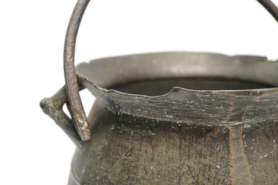 A 16th / 17th century bronze cauldron, 21.5cm tall with handle down. Condition - poor, losses and repairs to rim and body